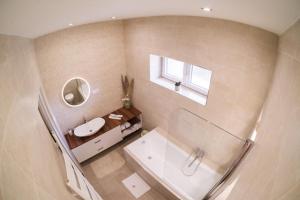 a bathroom with a tub and a sink and a mirror at Reforma Apartman in Szerencs