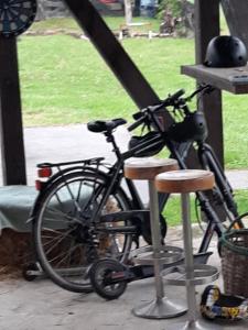 a bike is parked next to two stools at Ranch Farm Stay in Rakovica