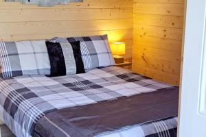 Cama en habitación con pared de madera en The Stunning Log House, en Wexford