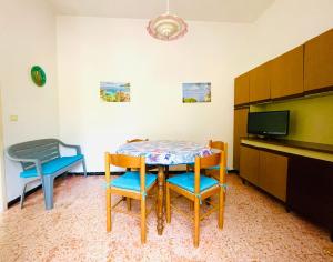 a room with a table and chairs and a tv at Appartamenti Viticcio Aurora e Fiorita - Goelba in Portoferraio