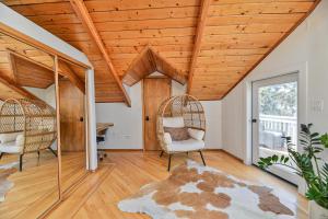 ein Wohnzimmer mit Holzdecken und Schaukelstühlen in der Unterkunft Huvila Haven Lake Front Home with Dock and Hot Tub 