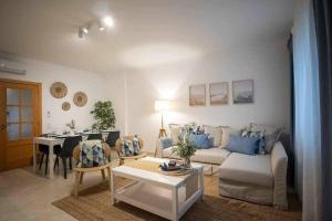 a living room with a couch and a table at Modern 3br Apt w/ Lg Terrace, Bbq, Ac & Parking in Tavira