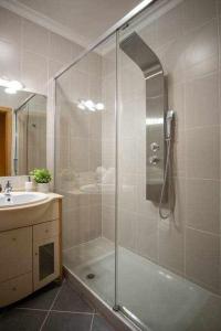 a bathroom with a shower and a sink at Modern 3br Apt w/ Lg Terrace, Bbq, Ac & Parking in Tavira