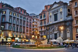 una via cittadina con una fontana di fronte agli edifici di Core e core a Napoli