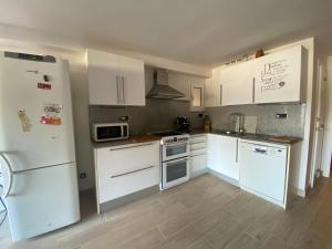 uma cozinha com electrodomésticos brancos e armários brancos em Tossa de mar Amplio Apartamento con vistas al mar em Tossa de Mar