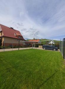 a yard with a car parked in front of a building at Apartaments Gory in Niedzica Zamek