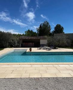 a swimming pool in front of a house at Charmant appartement calme à Paradou in Paradou