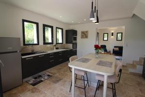 een keuken en woonkamer met een tafel en stoelen bij Charmant appartement calme à Paradou in Paradou