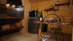 a kitchen with a table and a microwave and a refrigerator at Gîte de Terre et de Charme in Hamoir