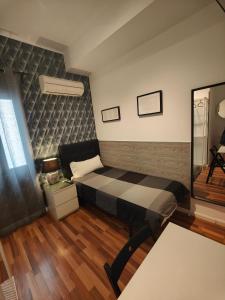 Habitación pequeña con cama y espejo. en SINGLE ROOMS en Madrid