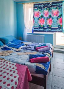 1 dormitorio con 2 camas y una ventana con rosas en Kolorowa Chata, en Ustronie Morskie
