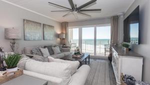 a living room with a couch and a ceiling fan at Total Remodel BEACHFRONT 5th Floor - 2 Bd & 2 Ba - Dunes of Panama in Panama City Beach