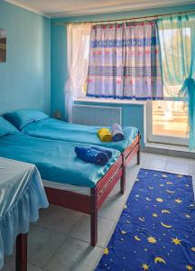 1 dormitorio con 2 camas individuales y ventana en Kolorowa Chata, en Ustronie Morskie