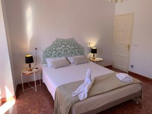 a bedroom with a large white bed and two lamps at Doranda Rooms Las Canteras in Las Palmas de Gran Canaria