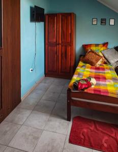 1 dormitorio con 1 cama con una manta colorida en Kolorowa Chata, en Ustronie Morskie