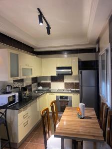 a kitchen with a wooden table with chairs in it at Casa Falaise Monastir in Monastir +17 photos