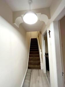 a hallway with a staircase with a light and a ceiling at Tods Lodge - Quiet area in Derry City in Derry Londonderry