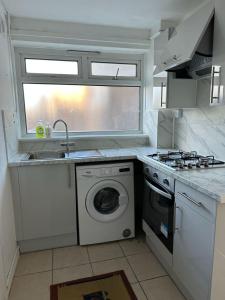 a kitchen with a sink and a washing machine at Cheerful double room for single use in London
