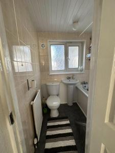 a small bathroom with a toilet and a sink at Cheerful double room for single use in London