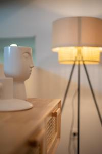 a white head sitting on a table next to a lamp at Olive Boutique Guesthouse in Vila Franca do Campo