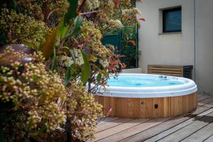 bañera de hidromasaje en una terraza de madera en Résidence Manon, en Monticello