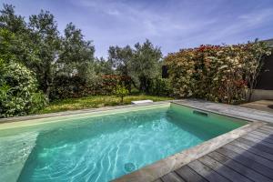 una piscina en una terraza de madera junto a un jardín en Résidence Manon, en Monticello