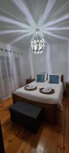 Un dormitorio con una cama grande y una lámpara de araña. en Casa do Espadanal, en Vila Real