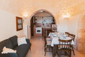 uma sala de estar com uma mesa e uma cozinha em Trulli Di Nonno Stefano em Locorotondo