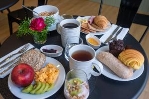 a table topped with plates of breakfast foods and coffee at Olive Boutique Guesthouse in Vila Franca do Campo