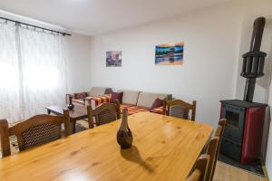 a living room with a table and a wood stove at Apartman OLGA in Perućac