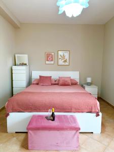 1 dormitorio con 1 cama grande con manta rosa en La Casa di Maurizio, en Montefiascone