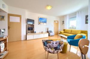 sala de estar con sofá amarillo y silla azul en Apartman Noel, en Krk