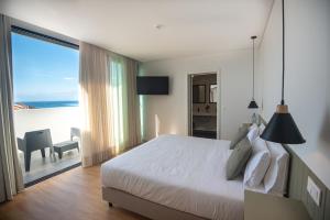 a bedroom with a bed and a view of the ocean at Olive Boutique Guesthouse in Vila Franca do Campo