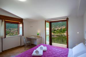a bedroom with a bed and a desk and a window at I colori della Luna in Agerola