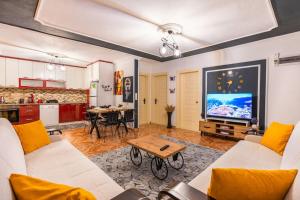 uma sala de estar com mobiliário branco e uma televisão de ecrã grande em Nefesim suit apart kaş kalkan em Kalkan