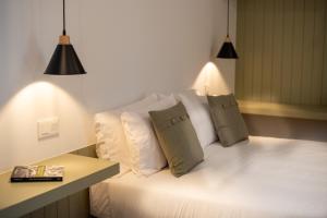 a white bed with two pillows and a table at Olive Boutique Guesthouse in Vila Franca do Campo