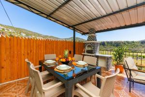 a patio with a table and chairs and a grill at Nefesim suit apart kaş kalkan in Kalkan