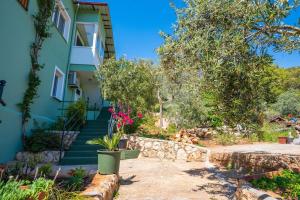 a house with stairs and flowers in front of it at Nefesim suit apart kaş kalkan in Kalkan