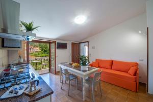 a living room with an orange couch and a table at I colori della Luna in Agerola