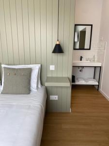 a bedroom with a white bed and a mirror at Olive Boutique Guesthouse in Vila Franca do Campo
