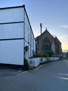 a white building on the side of a street at 8 Opera Suites, Llangollen in Llangollen