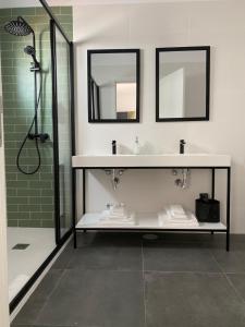a bathroom with a sink and a shower with mirrors at Olive Boutique Guesthouse in Vila Franca do Campo