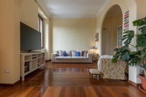 uma sala de estar com um sofá e uma televisão em BePlace Apartments in Lotto em Milão