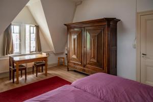 1 dormitorio con escritorio, 1 cama y armario de madera en J&J en Nijmegen