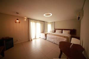 um quarto de hotel com duas camas e uma janela em Pousada Rangai em Maragogi