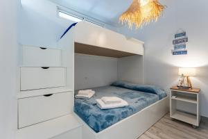 ein kleines Schlafzimmer mit einem Bett und einem Kronleuchter in der Unterkunft Rocas del Mar in Mijas