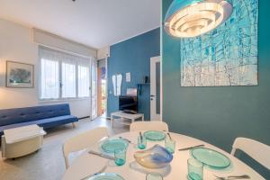uma sala de estar com uma mesa e cadeiras e um sofá em INTO THE BLUE Lavagna Seaside Flat em Lavagna
