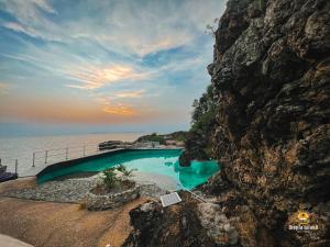 uma piscina ao lado de uma montanha rochosa em Utopia Island Resort em Batangas City