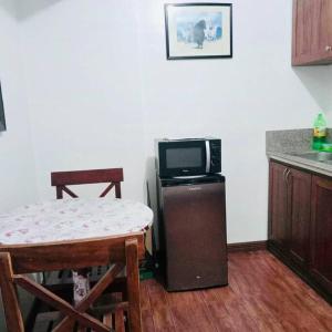 a kitchen with a small table and a tv on a counter at Isabelle Garden Villas 517 in Manila
