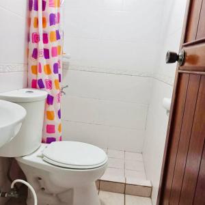 a bathroom with a toilet and a shower curtain at Isabelle Garden Villas 517 in Manila
